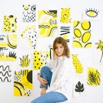 Woman in a creative indoor art studio with vibrant artwork on the walls.
